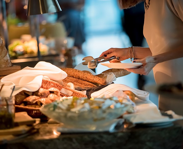 food items spread out on a table and people serving themselves